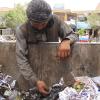 A homeless former drug addict rummages for food scraps and re-sellable items in Herat.